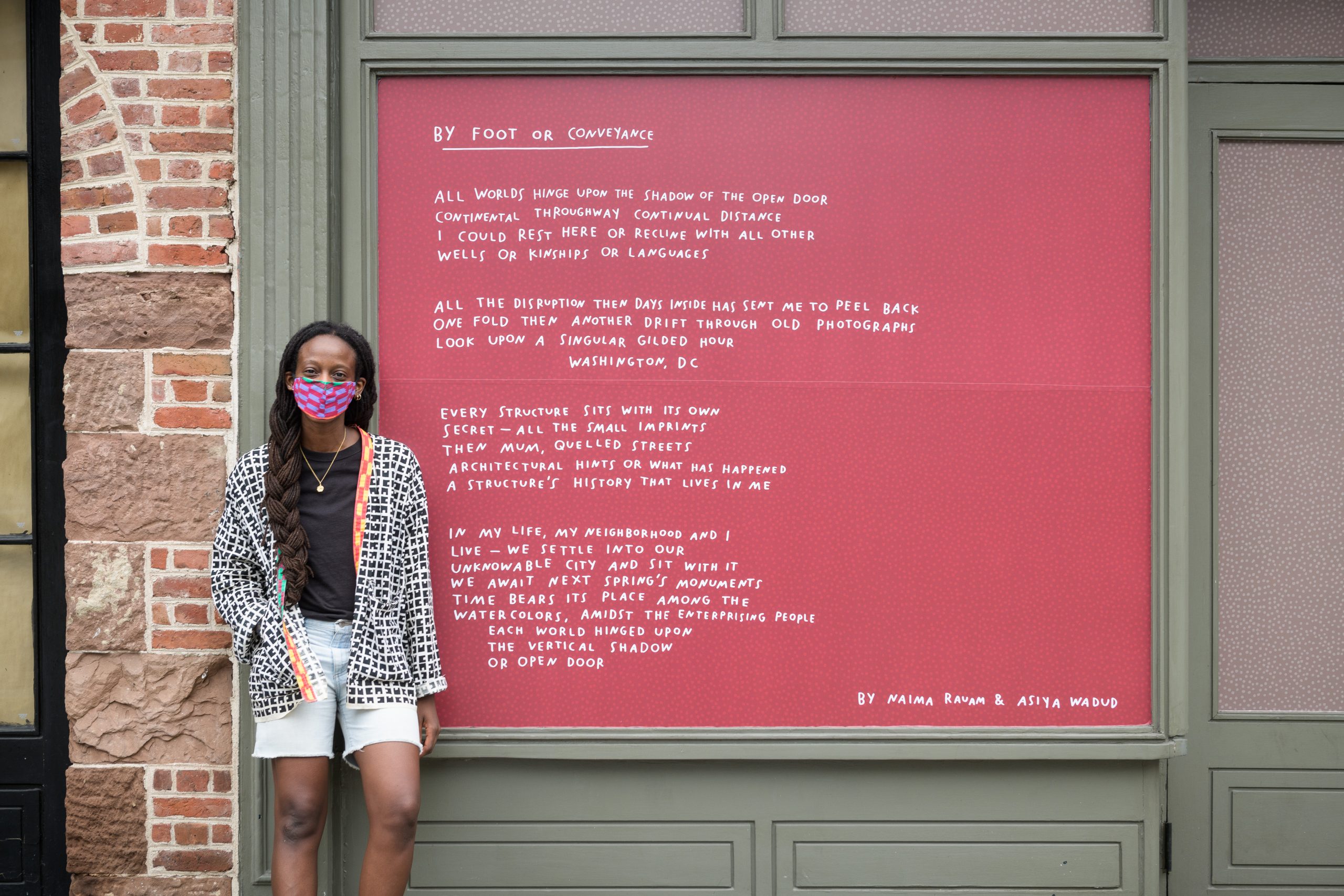 The poet Asiya Wadud stands by one of her pieces from “Echo Exhibit” (2020) in New York City’s Seaport district, co-presented by the Lower Manhattan Cultural Council (LMCC), the Seaport district and the Howard Hughes Corporation as part of River To River 2020: Four Voices.